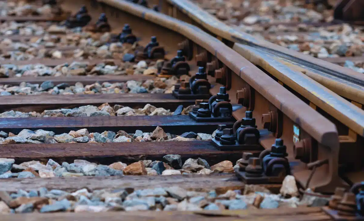 Close-up of railway track fastening system with bolts and clips that can be stripped and electroplated after years of service to restore protection.