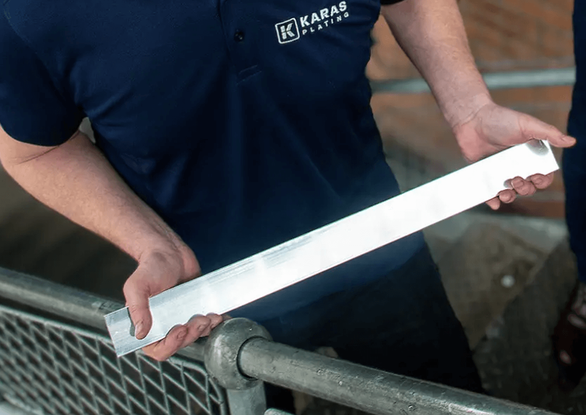 A worker at Karas holding silver plated copper busbar